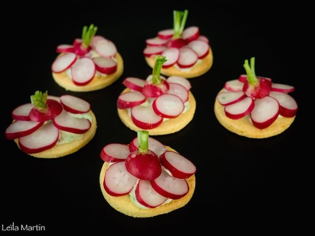 Une recette de radis servis sur des sablés au parmesan avec une crème de fanes de radis