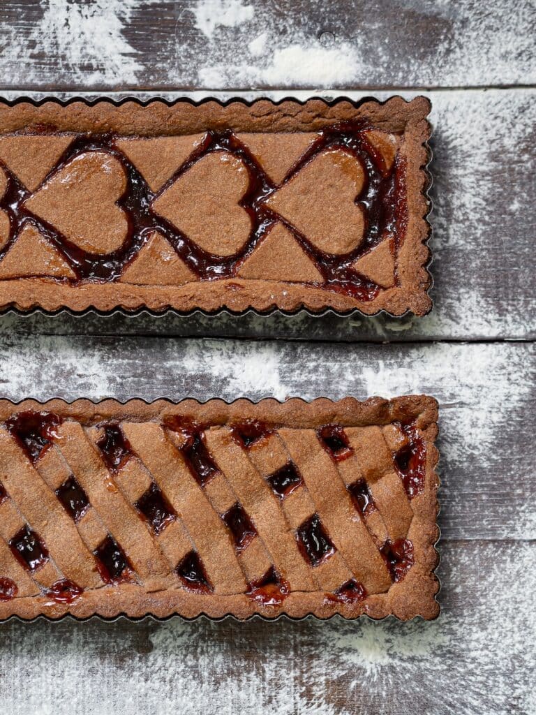 Deux tartes rustiques garnies de confiture sur table farinée