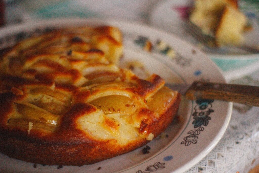 Gâteau fondant aux pommes entamé dans une assiette ancienne